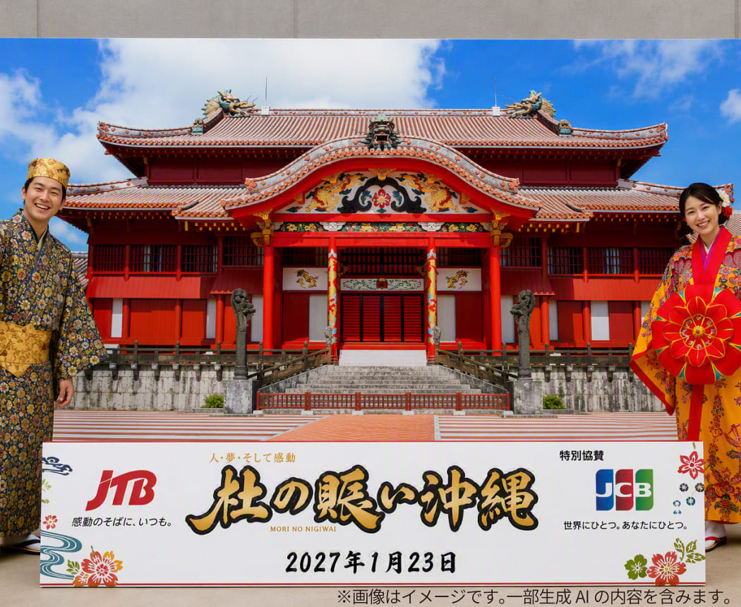 首里城を模したパネルの前で琉装を着て記念撮影する様子