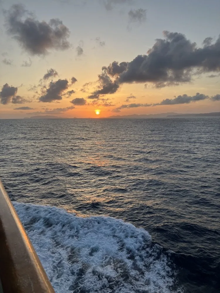 船尾から眺めた夕日と航跡