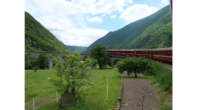 線路がカーブする場所は赤い列車を写真に収める絶好のチャンス！乗客は一斉にカメラを構えます。