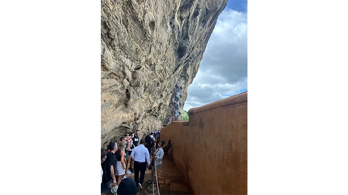 ミラーウォールの前でガイドさんの説明を聞く旅行者