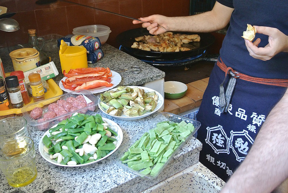 日本でお土産に買った前掛けでパエリアの準備をする友人