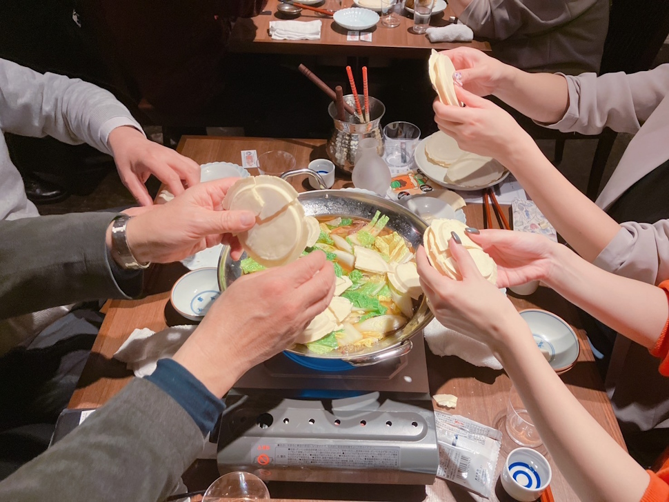 せんべいを割って鍋に入れる