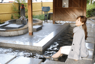 画像：足湯に浸かる女性